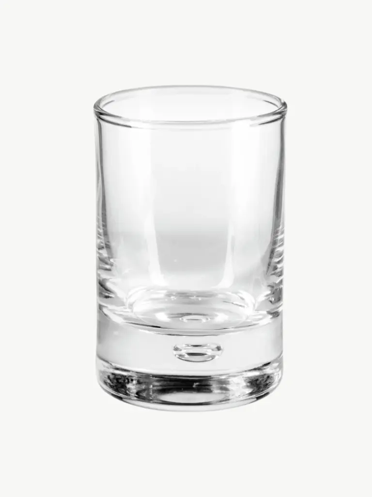 Kleines Schnapsglas aus Glas auf hellem Hintergrund