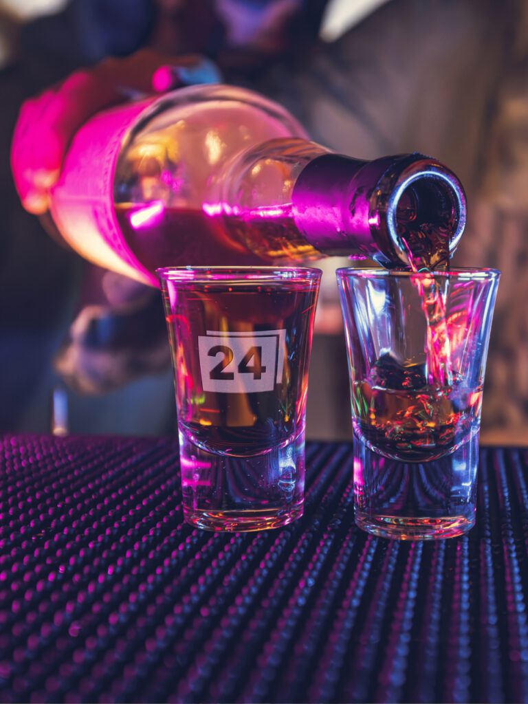 Zwei Schnapsgläser, eines mit Gravur „24“, wird befüllt
